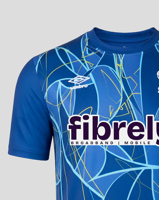 Chest view of blue junior goalkeeper shirt showing Umbro logo and fibrel sponsor across the front