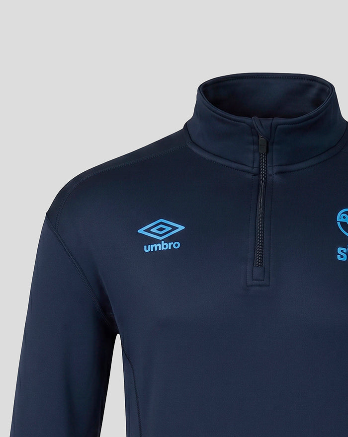 Close up of navy travel quarter zip showing blue Umbro logo on the chest