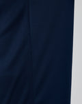 Close-up of navy knit fabric and side seam stitching on a training tee