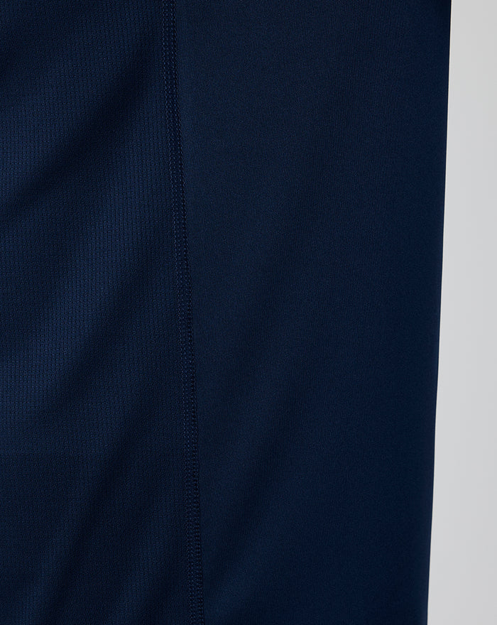 Close-up of navy knit fabric and side seam stitching on a training tee