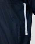 Close-up of navy training jacket fabric with a light blue vertical stripe beside a side pocket.